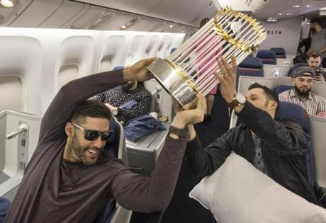 J.D. Martinez handed the World Series trophy off to Joe Kelly on the Red Sox charter flight home from winning the World Series in Los Angeles. 
