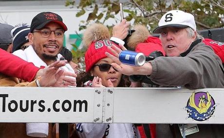 Boston, MA: 10-31-18: SECOND OF TWO PICTURES......The Globe's Stan Grossfeld (far right) makes the save as a can of beer thrown from the crowd below was heading for the Red Sox Mookie Betts as the Red Sox World Series parade went through Copley Square. (Jim Davis/Globe Staff) 
