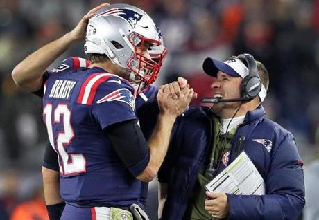 Foxborough, MA: 11-4-18: Patriots quarterback Tom Brady (12,left) gets a hand from offensive coordinator Josh McDaniels (right) as the clock was running down in the New England victory over the Packers. The New England Patriots hosted the Green Bay Packers in an NFL regular season Sunday night football game at Gillette Stadium. (Jim Davis/Globe Staff)
