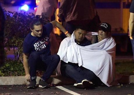 People comforted each other as they sat near the scene in Thousand Oaks, Calif. where a gunman opened fire Wednesday inside a country dance bar crowded with hundreds of people on ?college night.?

