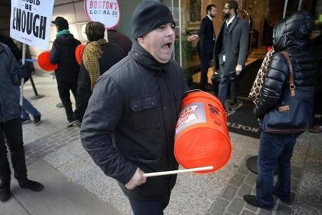 Boston, MA - 11/08/18 - Valter Mucaj (cq) bangs a plastic bucket and shouts union slogans in front of the Ritz as patrons exit the lobby. Banging on makeshift drums and shouting slogans, UNITE HERE Local 26 hotel workers are on strike at seven Marriott hotels in Boston, including in front of the Ritz Carlton. Residents of the swanky Millennium Place condos are used to putting on the ritz, but for the last six weeks they've been putting up with The Ritz: A cacophonous, 12-hour-a-day racket led by striking Marriott workers. Now, three condo associations from buildings nearby (but not associated with the labor dispute) are suing the city to get police to enforce noise ordinances in the first class action permit case in recorded history. (Lane Turner/Globe Staff) Reporter: (ramos) Topic: (09nestorritz)
