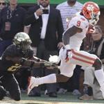 Clemson's Travis Etienne (9) is knocked out of bounds by Wake Forest's Essang Bassey (21) during the first half of an NCAA college football game in Charlotte, N.C., Saturday, Oct. 6, 2018. (AP Photo/Chuck Burton)