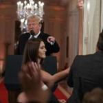 President Trump looks on as a White House aide attempts to take away a microphone from CNN journalist Jim Acosta during a news conference in the East Room of the White House on Wednesday. 