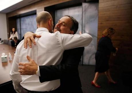 Peter DeMarco (left) and Dr. Assaad Sayah, chief medical officer for Cambridge Health Alliance, embraced Tuesday.
