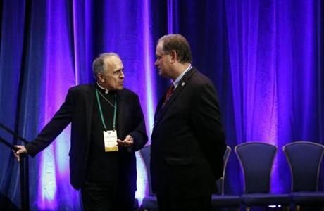 Cardinal Daniel DiNardo of the Archdiocese of Galveston-Houston, president of the United States Conference of Catholic Bishops, at left, speaks with James Rogers, the USCCB's chief communications officer, at the conference's annual fall meeting, Tuesday, Nov. 13, 2018, in Baltimore. (AP Photo/Patrick Semansky)

