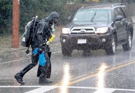 Gloucester, MA: 11-03-2018: In pouring rain, wearing a dry suit, diver Roy Mennell crossed Washington St. in Gloucester, Mass. Nov. 3, 2018. He had been diving with a group from the Metro West Dive Club at Plum Cove Beach. Mennell is from Cape Cod. Photo/John Blanding, Boston Globe staff story/ , Metro( )
