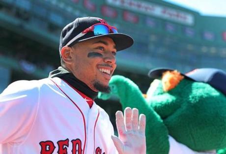 Boston, MA: 4/5/2018: The Red Sox Mookie Betts got a high five from team mascot Wally te Geeen Monster ss he ws introduced during pre game ceremonies. The Boston Red Sox hosted the Tampa Bay Rays in their 2018 MLB home Opening Day baseball game at Fenway Park. (Jim Davis/Globe Staff)
