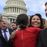 Rep.-elect Alexandria Ocasio-Cortez, D-N.Y., center in red, gets a hug from Rep.-elect Veronica Escobar, D-Texas, second from right, following a photo opportunity on Capitol Hill in Washington, Wednesday, Nov. 14, 2018, with the freshman class. (AP Photo/Susan Walsh)