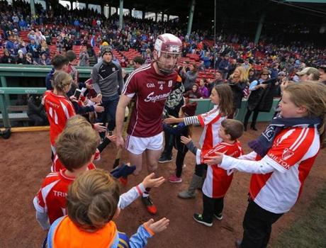 Youngsters greet players from the Galway team as they took the field at Fenway Park last year for a hurling match.

