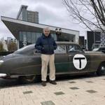 Former Governor Michael Dukakis stands in front of a 1949 Hudson he rode around in Friday in support of a North-South Rail Link.