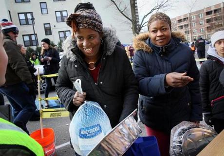 Martine Joseph (left) and Marie Alexia picked up turkeys and grocery packages Saturday at Catholic Charities Yawkey Center.
