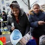 Martine Joseph (left) and Marie Alexia picked up turkeys and grocery packages Saturday at Catholic Charities Yawkey Center.