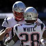 Chicago, IL - 10/21/2018 - (2nd quarter) New England Patriots quarterback Tom Brady (12) and New England Patriots running back James White (28) share an embrace after White's touchdown during the second quarter. New England Patriots vs. Chicago Bears at Soldier Field. - (Barry Chin/Globe Staff), Section: Sports, Reporter: Ben Volin, Topic: 21Patriots-Bears, LOID: 8.4.3538702313.