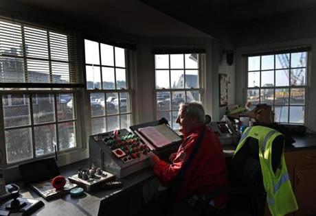 From his station beside the Eel Pond Bridge in Woods Hole, Michael Botelho watches boat and car traffic and works the controls to open and close the span, sometimes using a hand crank to accomplish the task.
Botelho sometimes using a hand crank to open and close the bridge.
