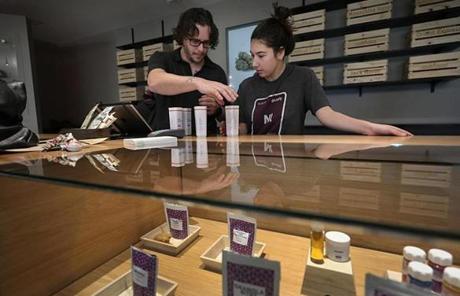 Employees, Nick Jarrin, left, and Kaylee Castell check out a customer buying medical marijuana at Cultivate.

