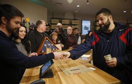 LEGAL POT SLIDER Leicester, MA, 11/19/2018 -- Iraq Veteran Stephen Mandile, of Uxbridge, hands his money to Cultivate President Sam Barber as he makes the first purchase at the opening of Cultivate, one of the state's first two pot shops. This the first day the store can sell recreational marijuana to adults 21 and older. (Jessica Rinaldi/Globe Staff) Topic: 21potopen Reporter: 
