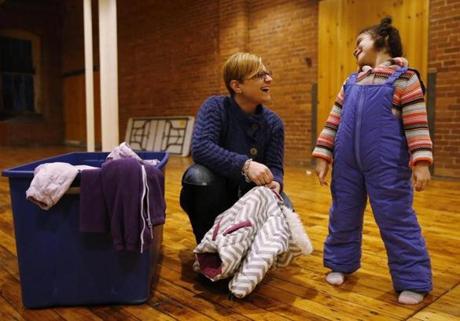 Laura Alefantis (left) helped Hadde Diaz, 4, find a pair of snow pants and a winter jacket as she volunteers at Debbie's Treasure Chest during Keeping The Merrimack Valley Warm Night. 
