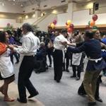 US Senator Edward M. Markey cut a rug with State Treasurer Deb Goldberg (in orange) at the event, with Mayor Martin J. Walsh (background, white shirt) and other volunteers. 