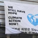 Greenpeace activists display a big banner reading 