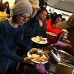Camp Fire evacuees wait in line to receive a free Thanksgiving meal at Sierra Nevada Brewery in Chico, Calif.