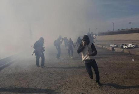 Migrants ran after US agents launched tear gas on Sunday at the US-Mexico border.
