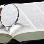 Dictionary with an magnifying glass on top