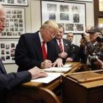 FILE - In this Nov. 4, 2015 photo, New Hampshire Secretary of State Bill Gardner watches, left, as Republican presidential candidate Donald Trump fills out his papers to be on the nation's earliest presidential primary ballot at The Secretary of State's office in Concord, N.H. Gardner said Friday, Sept. 8, 2017, that he will remain on the Presidential Advisory Commission on Election Integrity though he disagrees with voter fraud allegations made by the panel's vice chairman about his state. (AP Photo/Jim Cole, File)