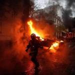 Fire crews worked to extinguish a burning car during protests Saturday in Paris.