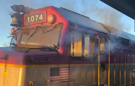 The engine of an MBTA commute rail line train is extinguished by Hanson firefighters on Nov. 29, 2018.  
