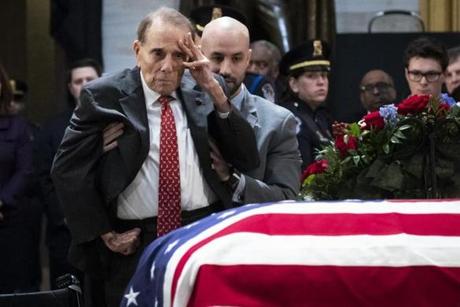 WASHINGTON, DC - DECEMBER 4: Former Senator Bob Dole stands up and salutes the casket of the late former President George H.W. Bush as he lies in state at the U.S. Capitol, December 4, 2018 in Washington, DC. A WWII combat veteran, Bush served as a member of Congress from Texas, ambassador to the United Nations, director of the CIA, vice president and 41st president of the United States. Bush will lie in state in the U.S. Capitol Rotunda until Wednesday morning. (Photo by Drew Angerer/Getty Images)
