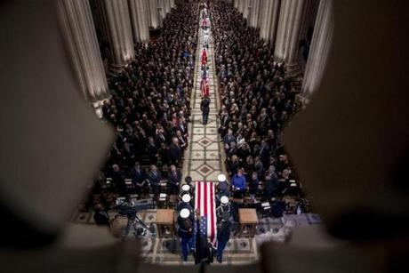 The flag-draped casket of former President George H.W. Bush was carried by a military honor guard.
