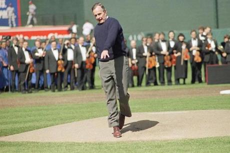 President George H.W. Bush reacts after throwing a one-hopper, the ceremonial first pitch, to Baltimore Orioles catcher Chris Hoiles to open Oriole Park at Camden Yards in Baltimore on Monday, April 6, 1992. The Orioles opened the new stadium playing the Cleveland Indians. Last year at the Texas Rangers home opener, the president also threw the ceremonial pitch on one hop. (AP Photo/J. Scott Applewhite)
