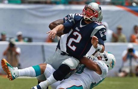 09/07/14: Miami Gardens, FL: Patriots quarterback Tom Brady was feeling the heat from the Dolphins defense all day, including this takedown as he threw an incompletion in the first quarter. The New England Patriots visited the Miami Dolphins for a season opening regular season NFL game at Sun Life Stadium. (Globe Staff Photo/Jim Davis) section: sports topic:Patriots-Dolphins (1)
