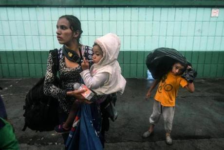 An Honduran migrant woman and their children, who are taking part in a caravan towards the United States, are pictured at the 