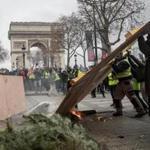 PARIS, FRANCE - DECEMBER 08: Protesters carry wood to make a barricade during the 'yellow vests' demonstration near the Arc de Triomphe on December 8, 2018 in Paris France. ''Yellow Vests' ('Gilet Jaunes' or 'Vestes Jaunes') is a protest movement without political affiliation which was inspired by opposition to a new fuel tax. After a month of protests, which have wrecked parts of Paris and other French cities, there are fears the movement has been infiltrated by 'ultra-violent' protesters. Today's protest has involved at least 5,000 demonstrators gathering in the Parisian city centre with police having made over 200 arrests so far. (Photo by Chris McGrath/Getty Images)