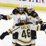 Boston Bruin defenseman Torey Krug (47) celebrates his winning overtime goal with teammates Brad Marchand (63) and David Krejci (46) at the end of NHL hockey overtime action against the Ottawa Senators, in Ottawa, Sunday, Dec. 9, 2018. (Fred Chartrand/The Canadian Press via AP)