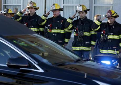 Firefighters salute as a hearse carrying fallen firefighter Christopher J. Roy passes by his fire station Monday  in Worcester.  
