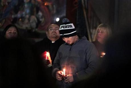 Edgar Mejia, lit candle in hand, at Thursday?s vigil for his daughters, who were killed Dec. 9.
