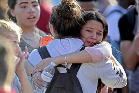 Students released from a lockdown embrace following following a shooting at Marjory Stoneman Douglas High School in Parkland, Fla., Wednesday, Feb. 14, 2018. (John McCall/South Florida Sun-Sentinel via AP)
