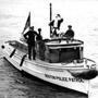 Globe Santa caught a ride on a police boat in Boston Harbor in 1956.