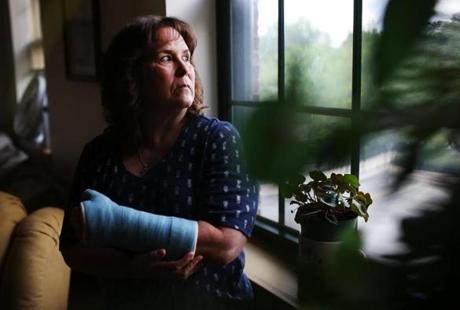 METHUEN, MA - 06/25/2018 Bernadette Coughlin stands in her living for a portrait nearly one month after she fell and broke her wrist while at work. After the fall, Bernadette was required to take a drug test and her occasional recreational marijuana use led to a positive result. She then lost her job. Erin Clark for the Boston Globe
