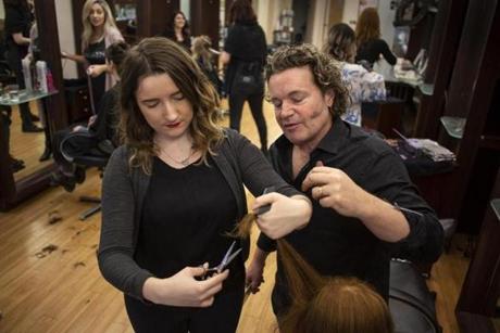 Melanie Warner left works on her hair cutting techniques with educator/stylist Alex Paulsen at Salon Herdis in Northampton, Mass. The owner of Salon Herdis is pre-emptively raising the wages of entry-level employees.

