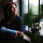 METHUEN, MA - 06/25/2018 Bernadette Coughlin stands in her living for a portrait nearly one month after she fell and broke her wrist while at work. After the fall, Bernadette was required to take a drug test and her occasional recreational marijuana use led to a positive result. She then lost her job. Erin Clark for the Boston Globe