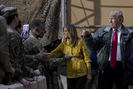 President Donald Trump and first lady Melania Trump greet members of the military at a hangar rally at Al Asad Air Base, Iraq, Wednesday, Dec. 26, 2018. (AP Photo/Andrew Harnik)
