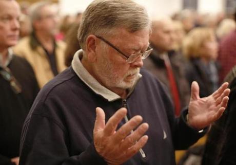 Bob Richardson prayed Saturday at St. George Catholic Church during a Mass honoring teens killed in a cabin fire in 1968.
