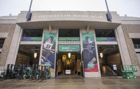 In this Dec. 21, 2018, photo, large graphics are placed around Notre Dame Stadium as crews work to set up the stadium for the NHL Winter Classic hockey game between the Chicago Blackhawks and the Boston Bruins in South Bend, Ind. (Robert Franklin/South Bend Tribune via AP)
