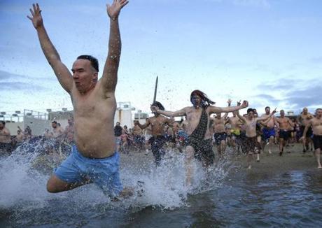 People run into the water during the L Street Brownies? annual new year polar plunge.  
