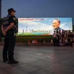 A group of visitors took a group photo in front of a poster of Chinese former leader Deng Xiaoping in Shenzhen, China. 
