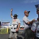 Locked-out workers picketed outside a National Grid facility in Malden in September. The union and the company announced a tentative agreement late Wednesday.