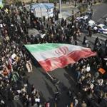 A demonstrator waved a huge Iranian flag during a pro-government rally in Mashhad, Iran, Thursday. 